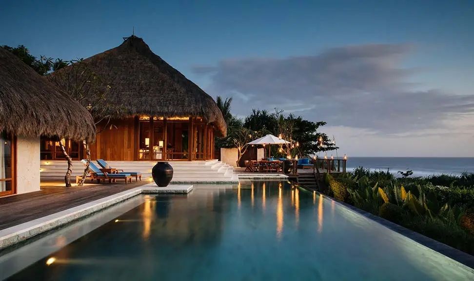 Raja Mandaka Villa am Abend mit beleuchtetem Pool und Meeresblick
