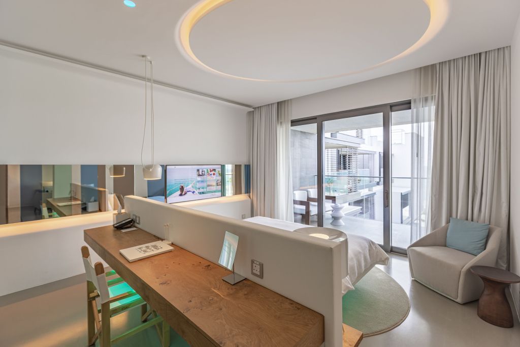 Elegante Suite mit modernem Design, offener Wohnbereich und Balkon mit Poolblick.