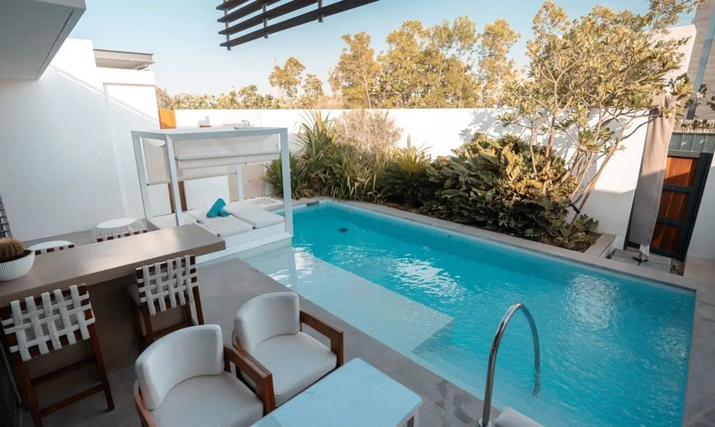 Privater Pool mit Liegestühlen und grüner Umgebung