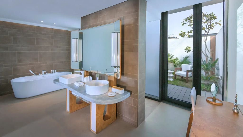 Badezimmer mit Doppelwaschbecken und Zugang zur Terrasse