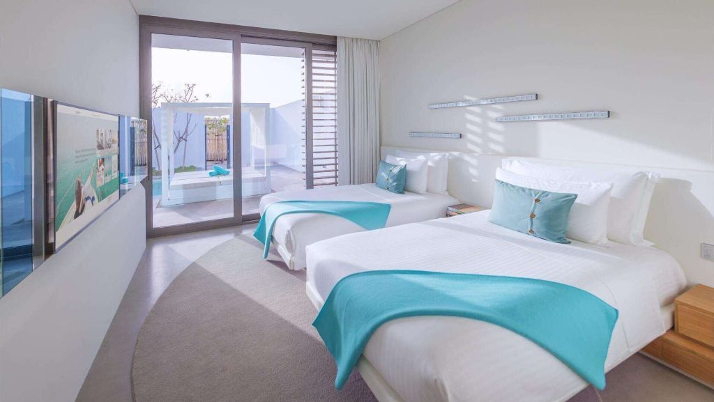 Helles Schlafzimmer mit zwei Einzelbetten in der Ultimate Villa des Nikki Beach Resorts