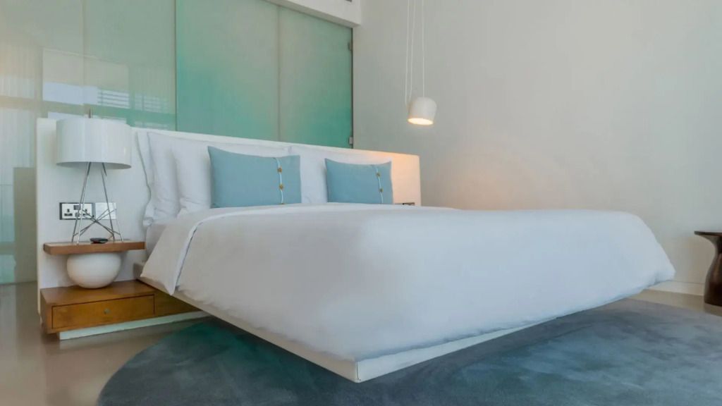 Modernes, helles Schlafzimmer mit großem Doppelbett und blauen Akzenten