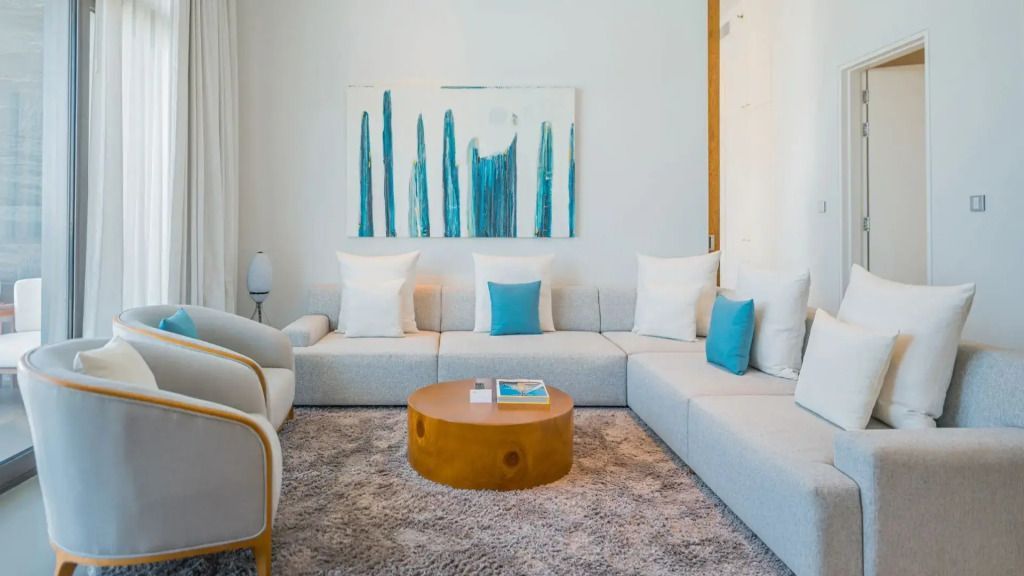 Gemütliche Sitzecke mit blau-weißen Kissen und modernem Kunstwerk