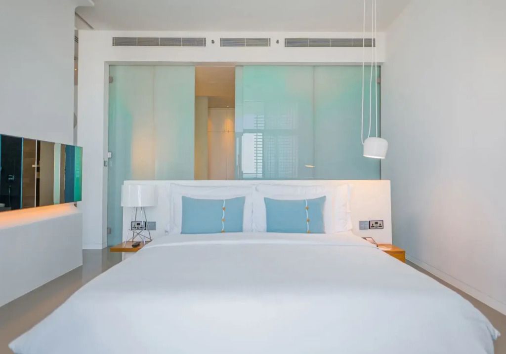 Elegantes Doppelbett mit blauen Akzenten in modernem Zimmerdesign