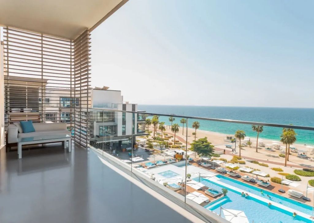 Balkon mit Blick auf den Pool und das Meer unter blauem Himmel