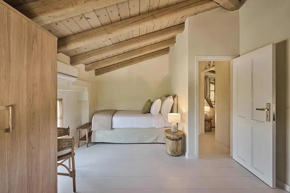 Charmantes Zimmer mit rustikalem Holzbalken, einem Einzelbett und stilvoller Einrichtung.
