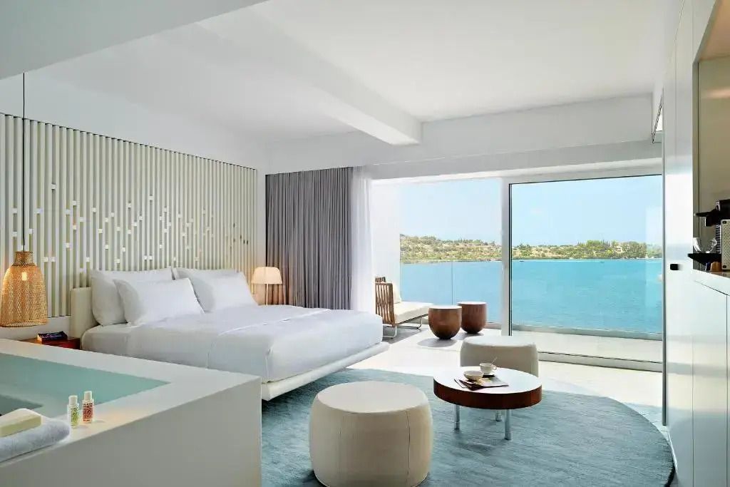 Moderne Suite mit großem Bett und Meerblick durch Panoramafenster