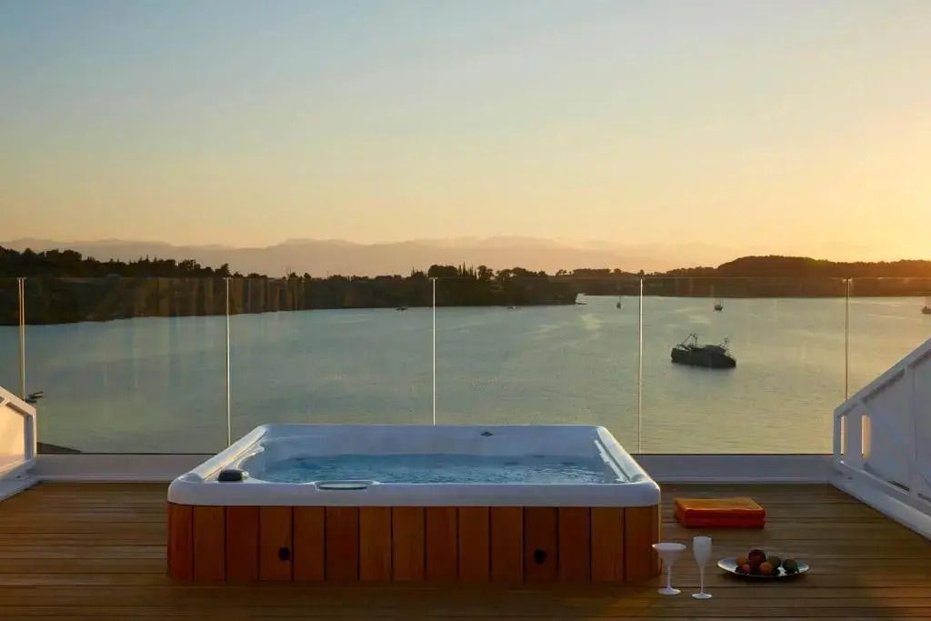 Whirlpool auf Terrasse mit Aussicht auf das Meer bei Sonnenuntergang