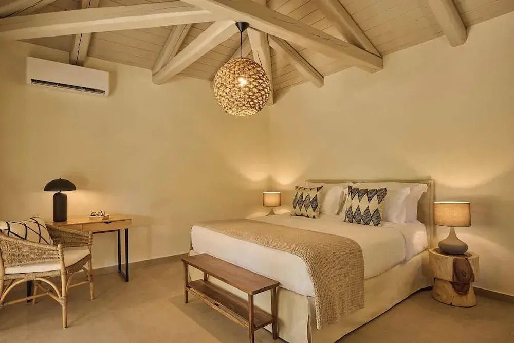 Elegantes Schlafzimmer mit Holzbalkendecke und stilvoller Beleuchtung
