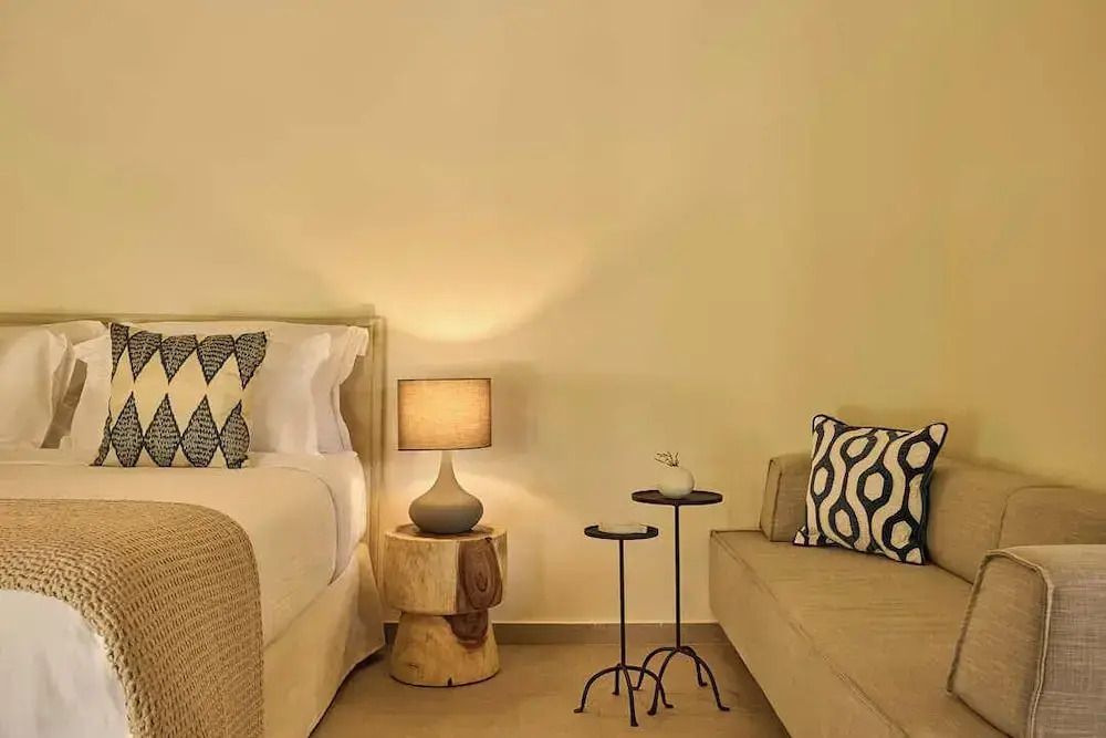 Komfortable Sitzecke neben Bett mit eleganter Lampe und Tisch