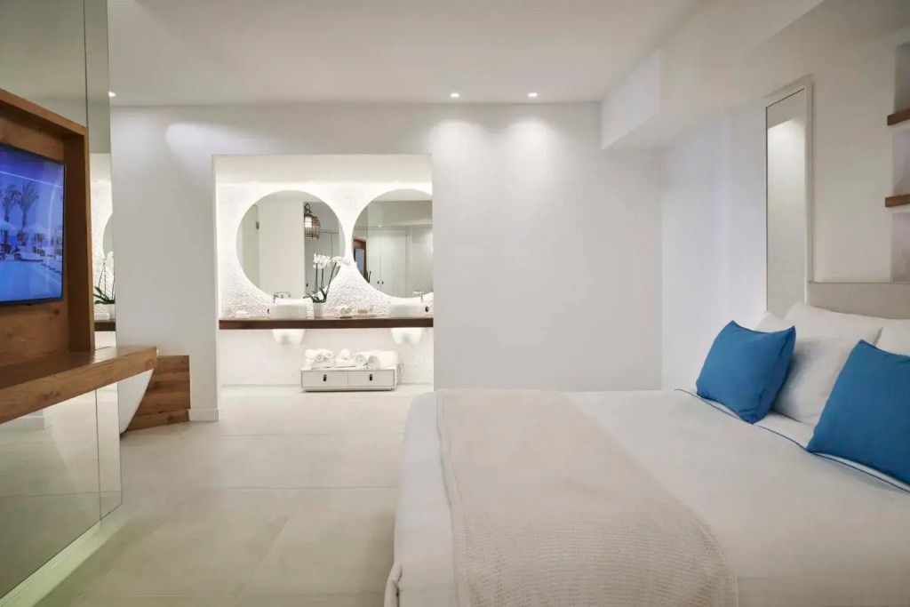 Geräumiges, modernes Schlafzimmer mit Doppelbett und großem Spiegel