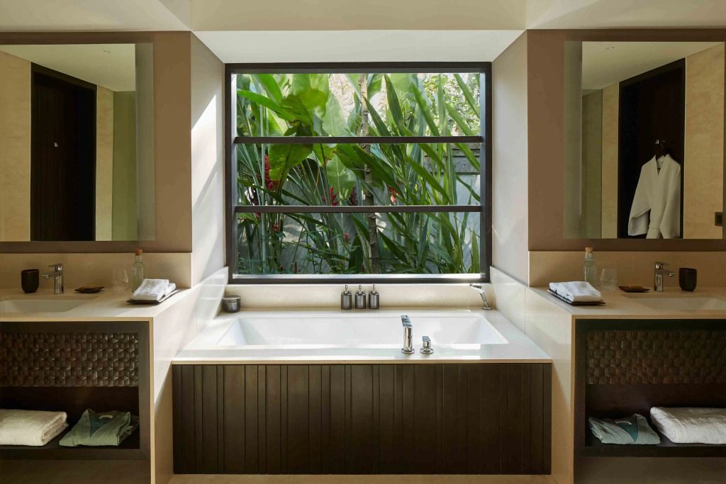 Luxuriöses Badezimmer mit Badewanne und Blick in den Garten