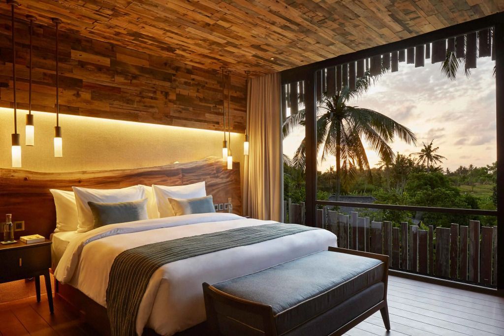 Luxuriöses Schlafzimmer mit Holzakzenten und Blick auf Sonnenuntergang