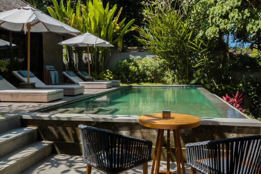 Privater Pool mit Liegestühlen und üppiger Vegetation in der Villa.