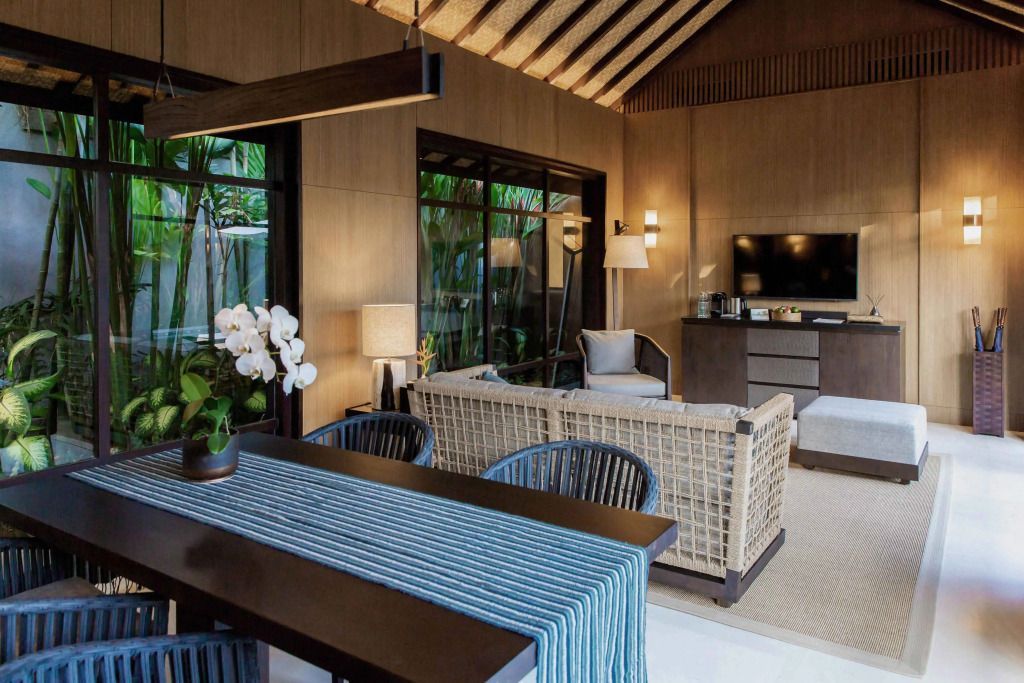 Elegantes Wohnzimmer mit moderner Einrichtung und großen Fenstern.