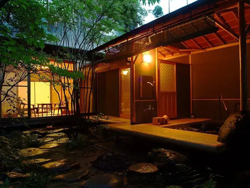 Japanischer Innenhof bei Nacht beleuchtet mit traditioneller Architektur und Pflanzen