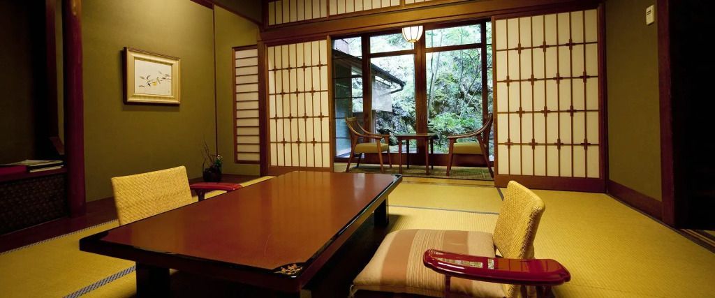Traditionelles japanisches Zimmer mit Tatamimatten und Blick auf einen grünen Garten.