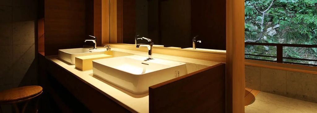 Modernes Waschbecken mit stilvoller Beleuchtung im Hotelbad