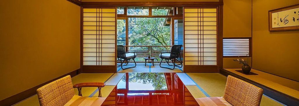 Sitzbereich mit traditioneller japanischer Einrichtung und Blick auf grünen Garten