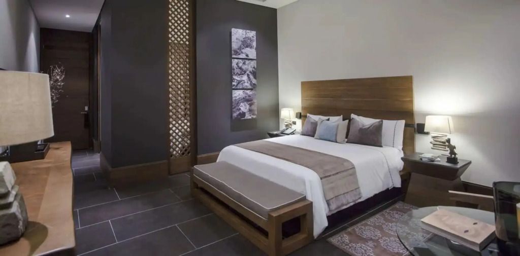 Stilvolles Schlafzimmer mit Doppelbett und moderner Kunst an der Wand.