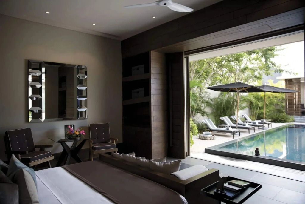 Offenes Schlafzimmer mit Blick auf privaten Pool und Garten
