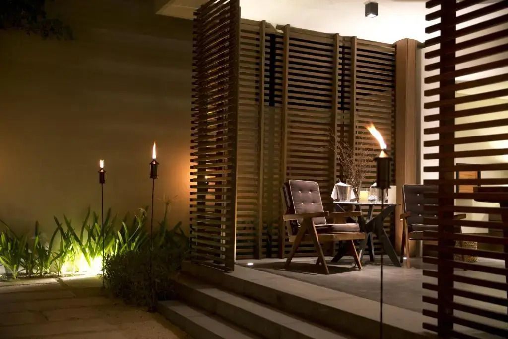 Gemütliche Terrasse mit stimmungsvoller Beleuchtung und stilvollen Möbeln bei Nacht