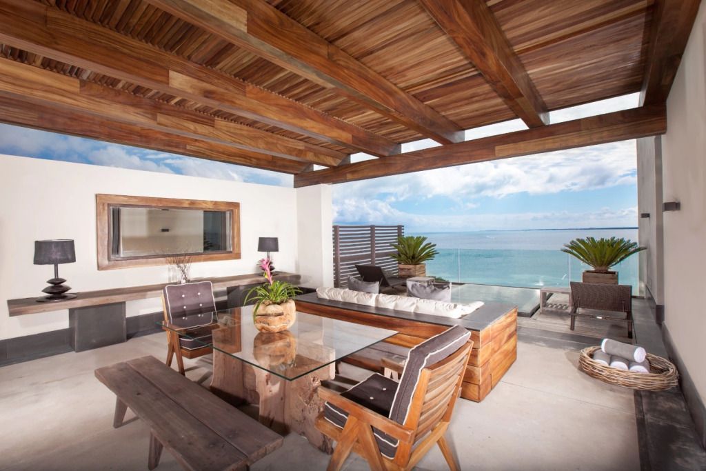 Geräumige Terrasse mit Meerblick, Holzmöbeln und bequemen Sitzgelegenheiten