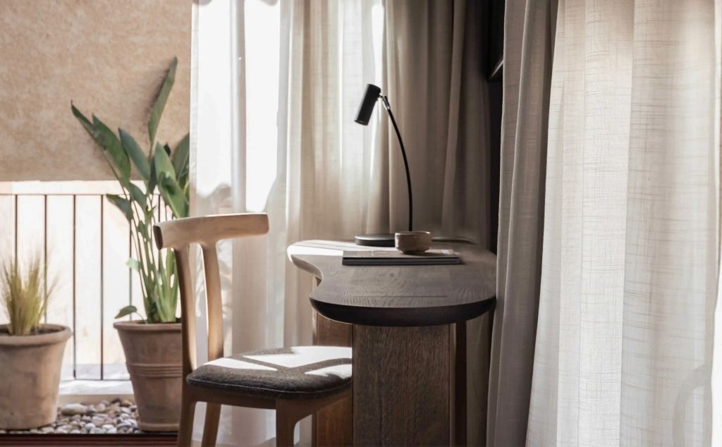 Gemütliche Sitzecke im Deluxe-Zimmer mit natürlichem Licht und stilvollem Schreibtisch