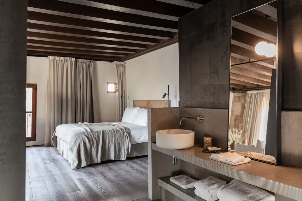 Suite Schlafzimmer mit Doppelbett und moderner Einrichtung. Stilvolle Holzdetails.