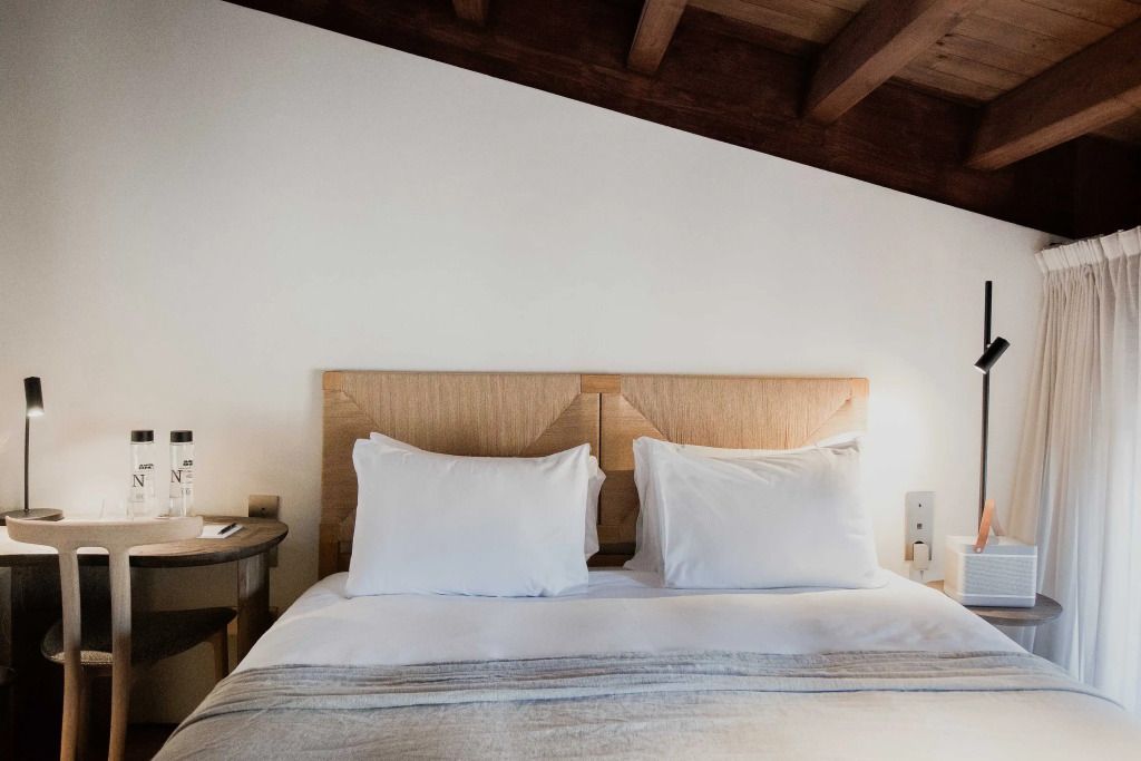 Gemütliches Bett mit Holzrahmen und weißen Kissen im Superior Dachboden