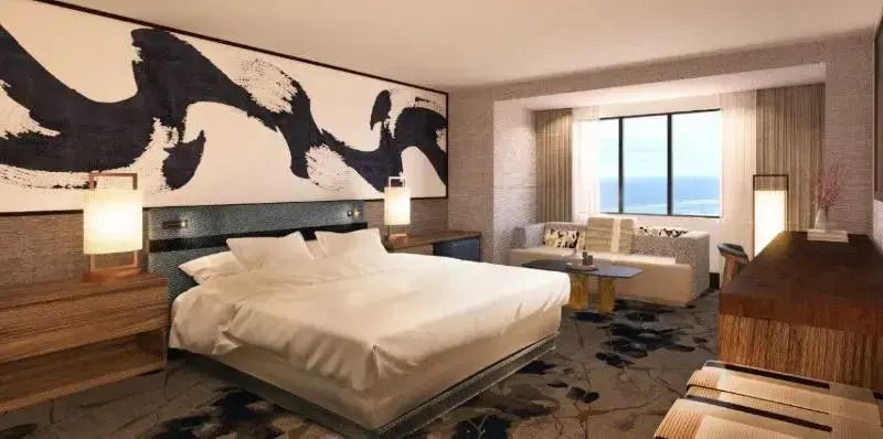 Modernes Hotelzimmer mit Doppelbett und Meerblick durch großes Fenster