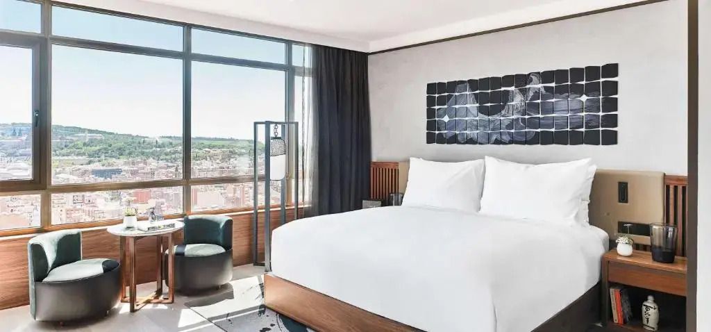 Helles Schlafzimmer mit großem Bett und weitem Fensterblick in der Zen Junior-Suite