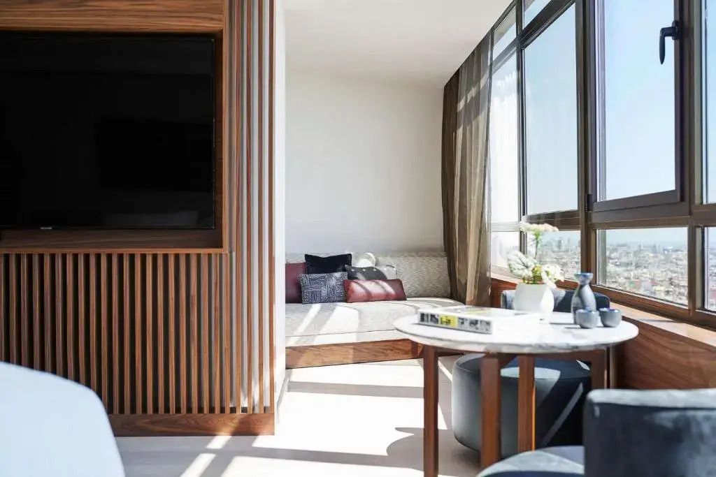 Sitzecke mit Tisch und Sofa in einer lichtdurchfluteten Zen Junior-Suite
