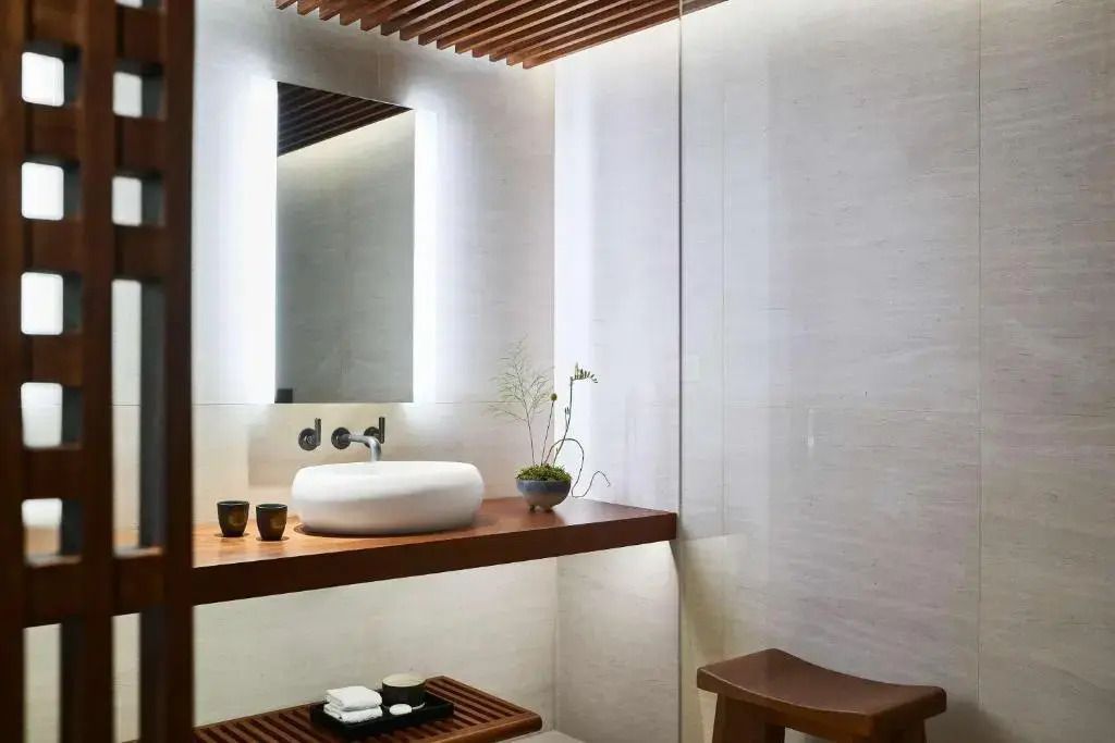 Schlichtes Badezimmer mit Holzdetails und Waschbecken in der Zen Junior-Suite