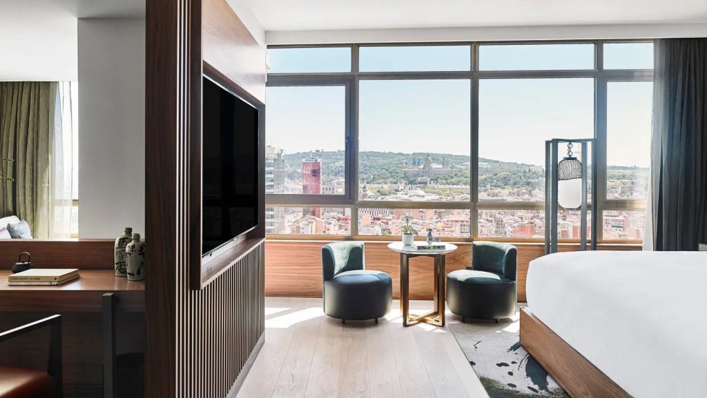 Helles Hotelzimmer mit großem Fenster und Blick auf die Stadt