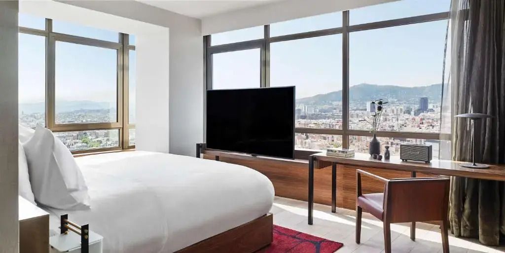 Helles Schlafzimmer mit großem Fenster und Stadtblick