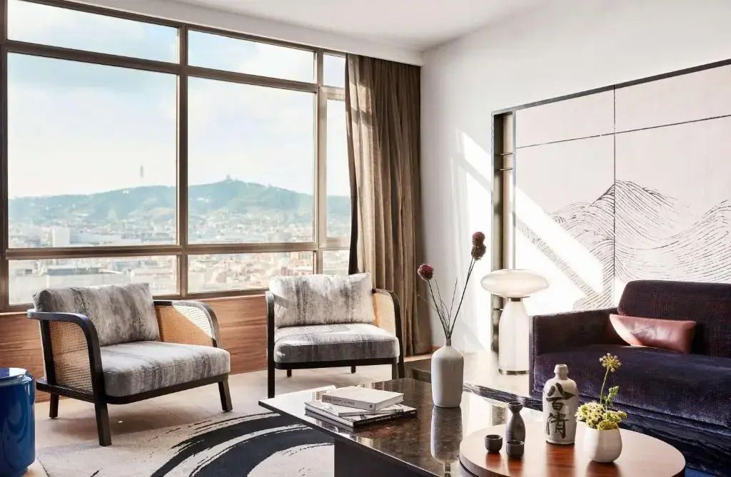 Gemütlicher Wohnbereich mit großer Fensterfront und Aussicht auf die Stadt