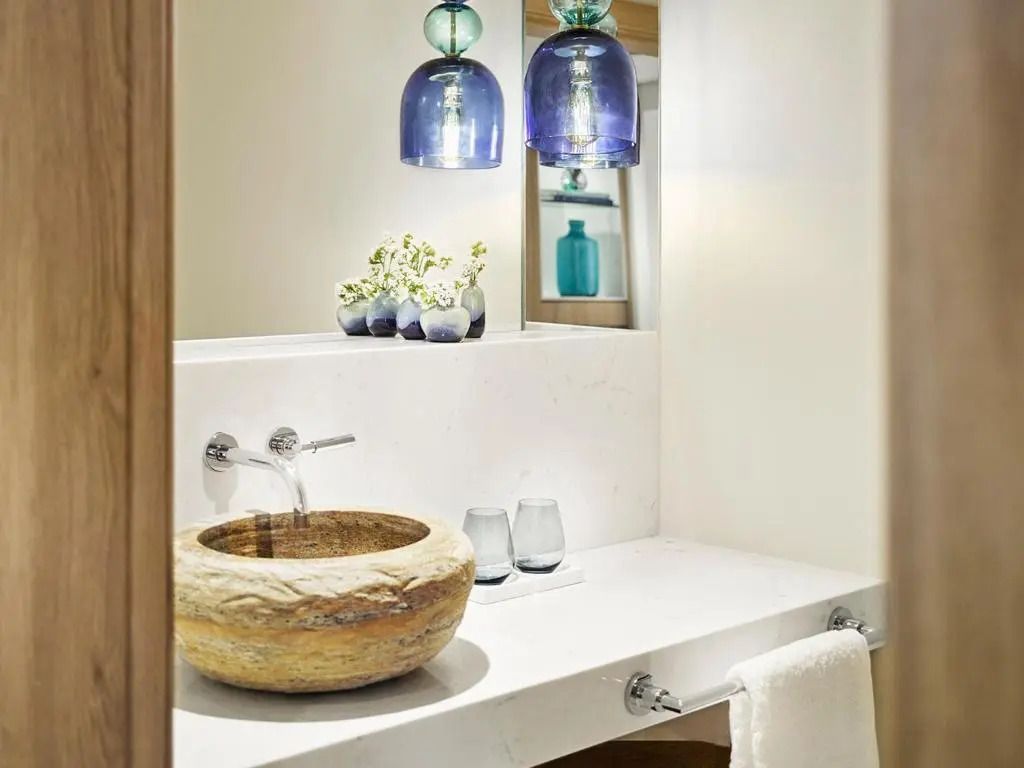 Kleines Badezimmer mit rustikalem Waschbecken und blauen Akzenten.