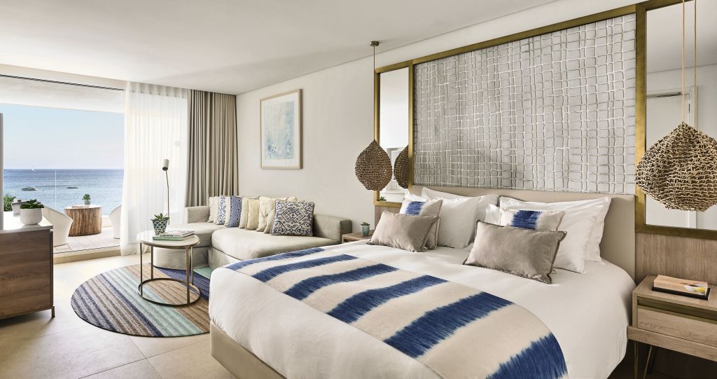 Elegantes Doppelbett in der Junior-Suite mit modernen Dekorelementen und beigem Sofa