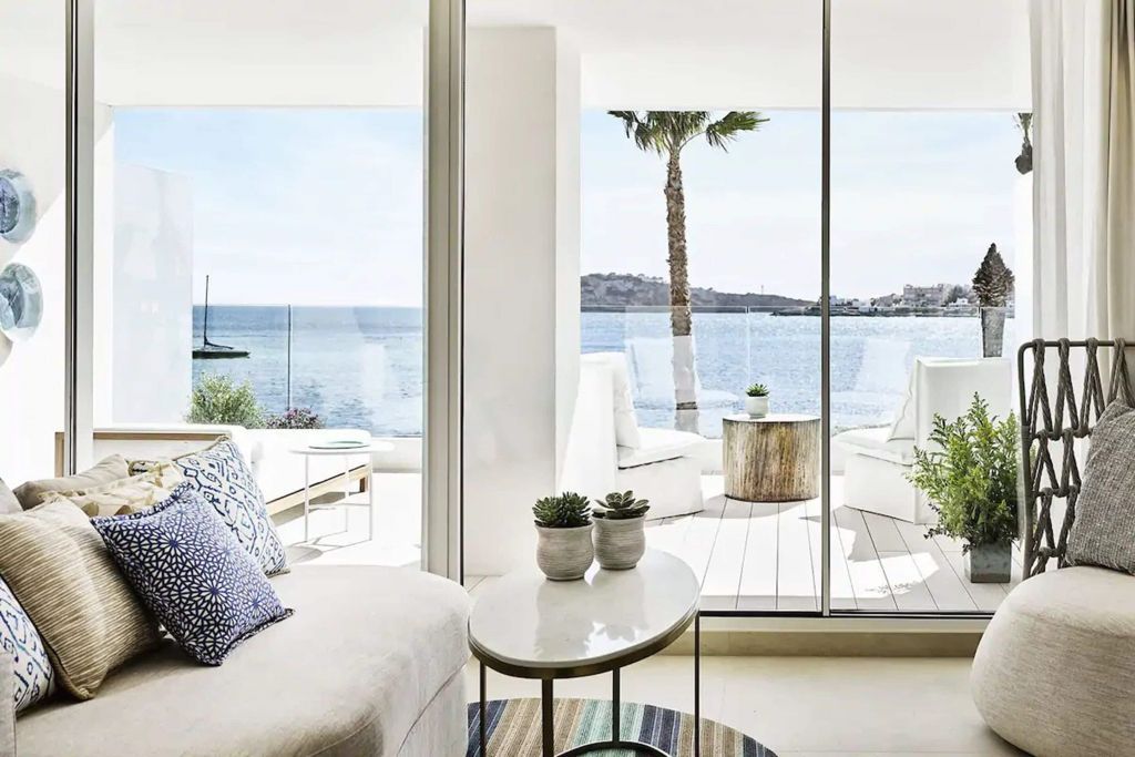 Panoramafenster mit Blick aufs Meer, stilvolle Lounge-Möbel.