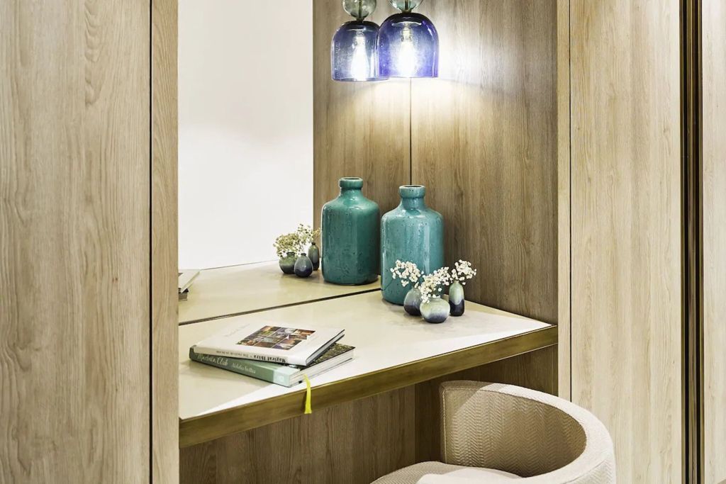 Gemütlicher Schreibtisch mit dekorativen Vasen und Wandbeleuchtung im Holzdesign