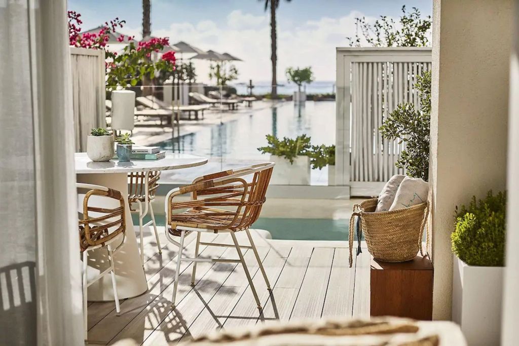 Terrasse mit Blick auf den Pool und das Meer im Hintergrund mit stilvollen Möbeln
