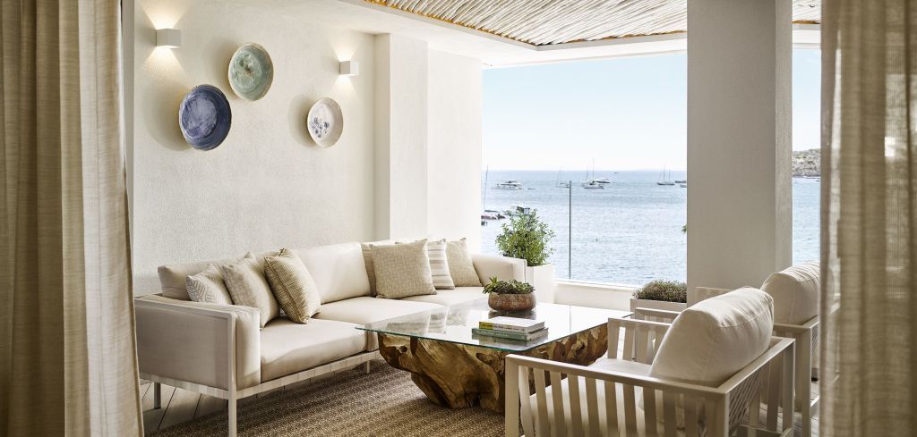 Helle Lounge mit Blick auf das Meer und stilvolle, helle Möbel