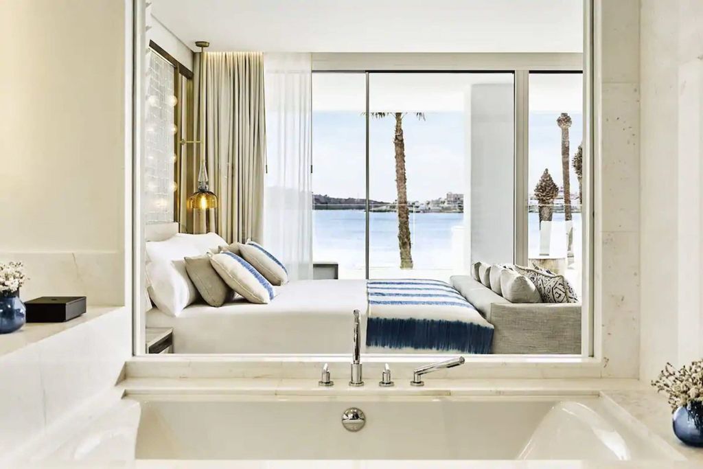 Offenes Badezimmer mit Blick auf das Meer und das Doppelbett in der Junior-Suite