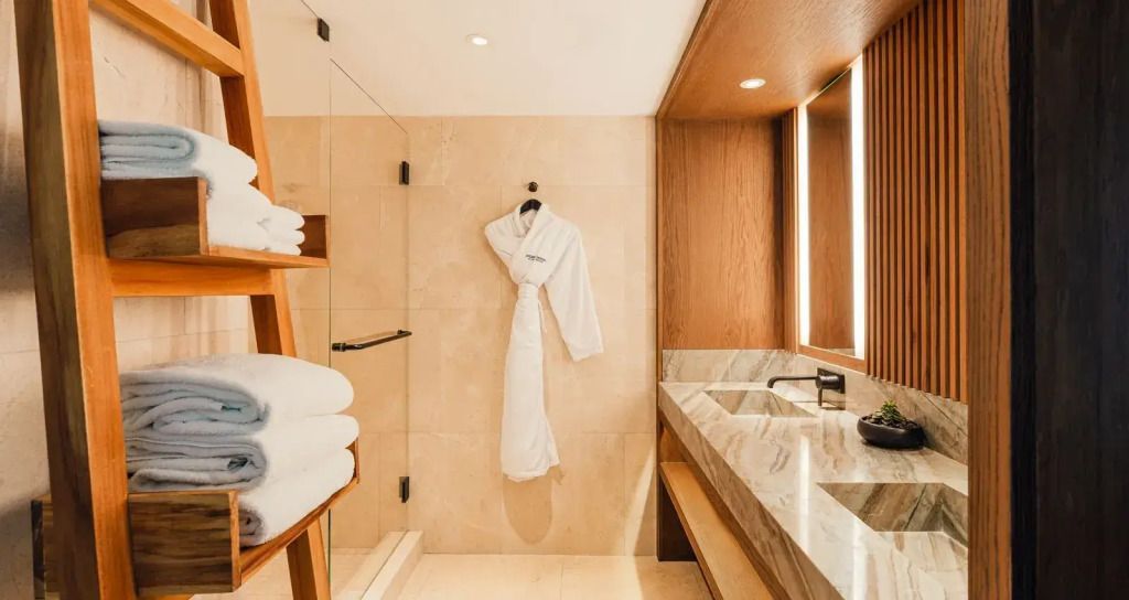 Luxuriöses Badezimmer mit Marmorwaschbecken und Bademantel im Nobu Hotel