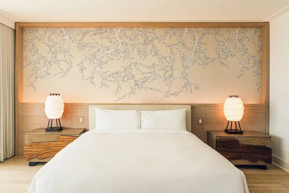 Gemütliches Doppelbett mit kunstvoller Wanddekoration in der Suite