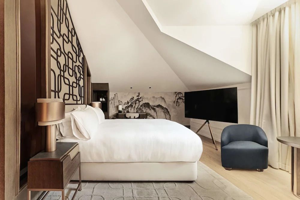 Großzügiges Zimmer unter Dachschräge mit modernem Dekor und Kunst an den Wänden