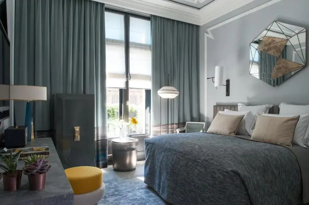 Modernes Superior Doppelzimmer mit großen Fenstern und Designerbeleuchtung