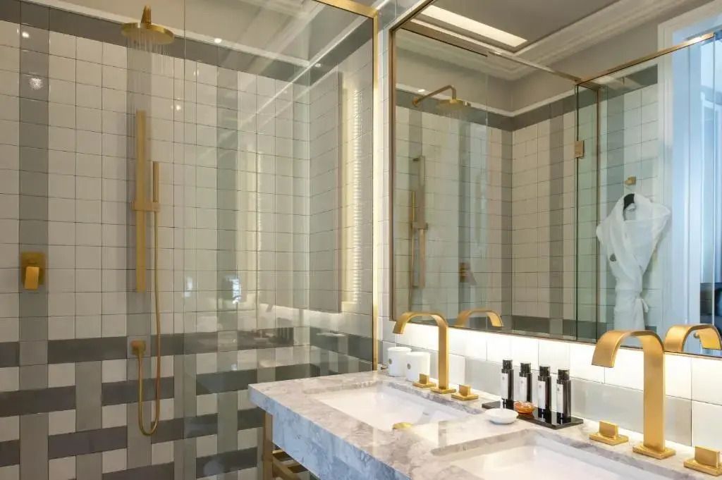 Hochwertiges Badezimmer mit Marmordoppelwaschbecken und goldener Armatur