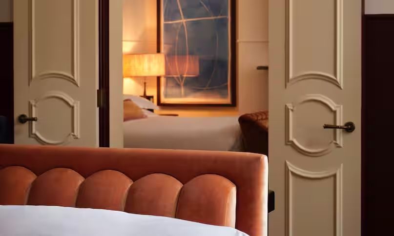 Blick durch eine elegante Suite mit warmen Beleuchtungselementen und Kunst an der Wand